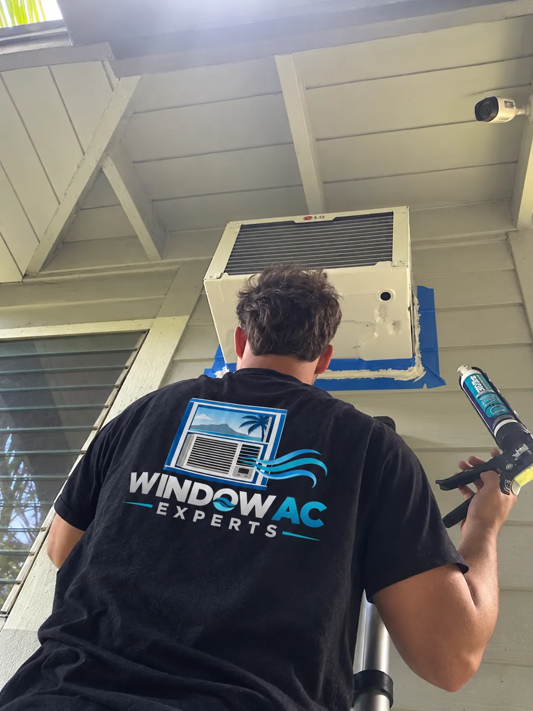 Window AC Experts technician carefully finishing an air conditioning installation