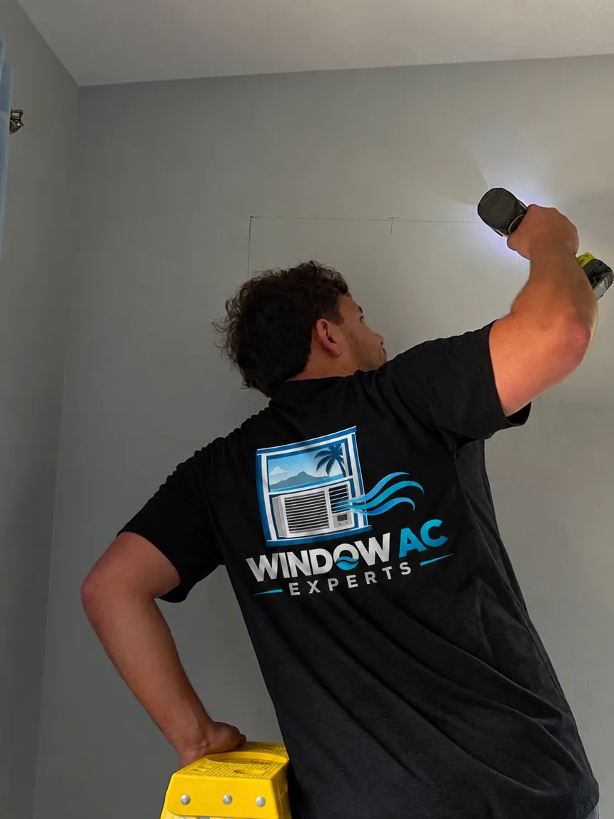 Window AC Experts technician measuring an opening for a window AC installation